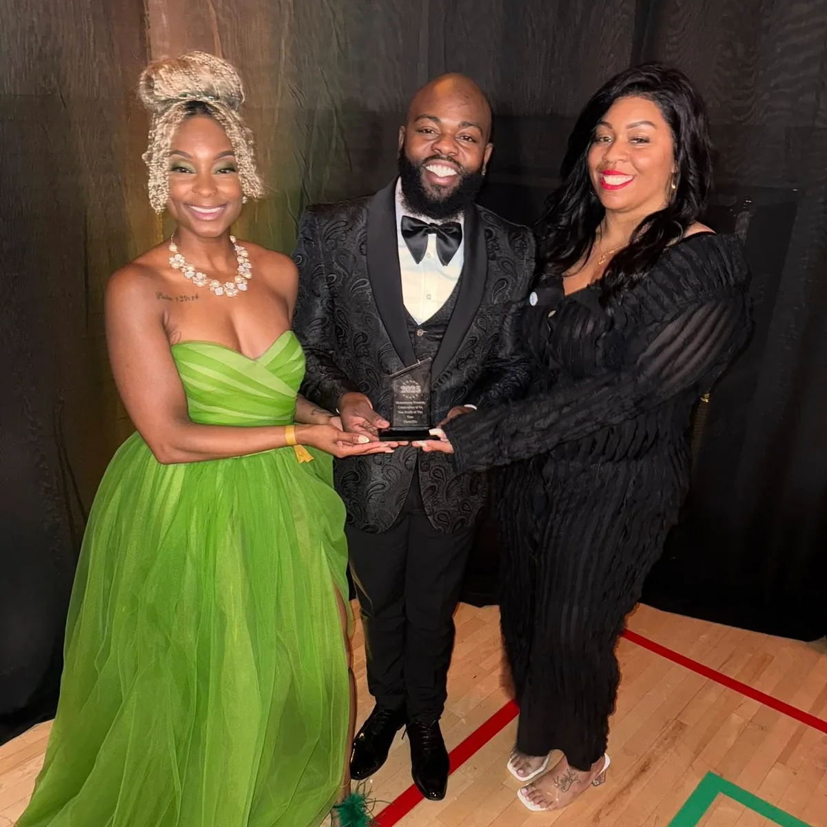 Them2Us leadership holding the 2025 Celebration of Us Non-Profit of the Year award